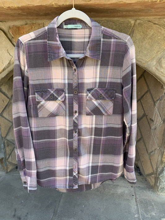 A Stevie Nicks Flannel Long Sleeve Shirt hanging on a stone wall.