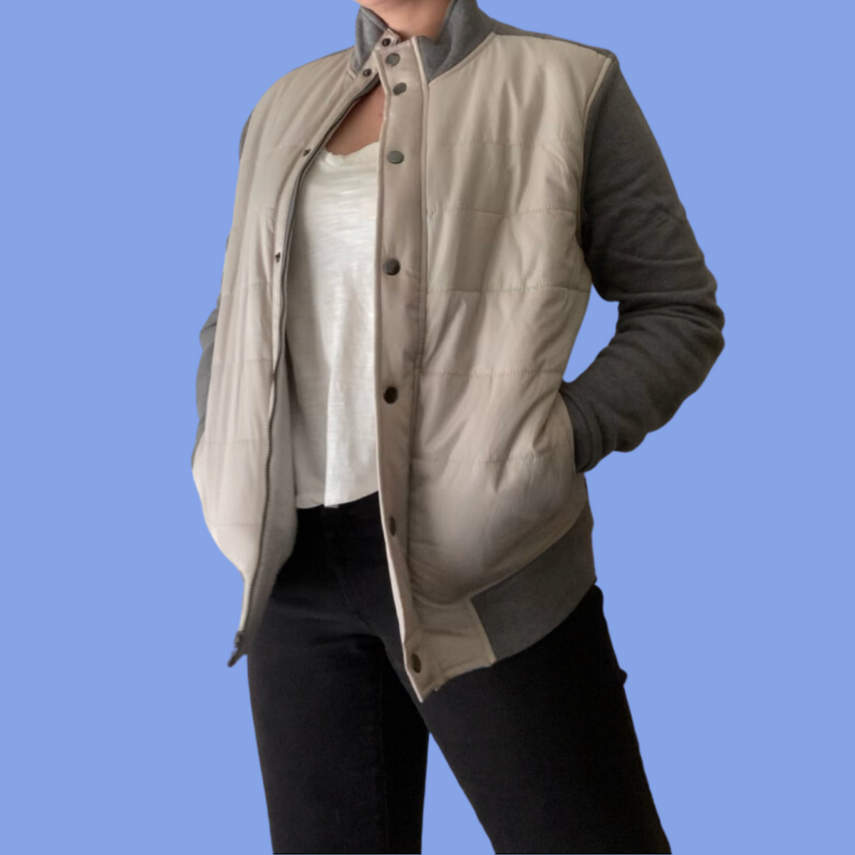 A woman wearing a beige jacket and black pants.