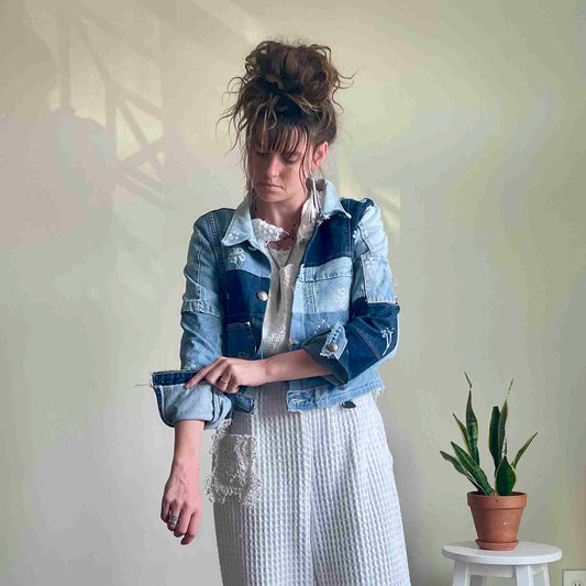 a woman standing in front of a white wall.