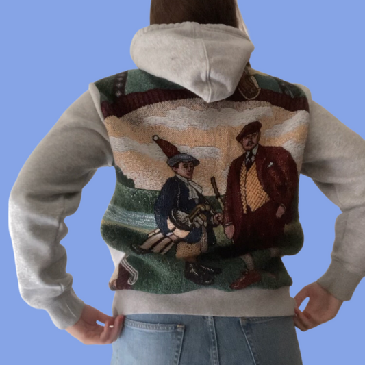 A woman wearing a hoodie with a picture of a man and a woman.