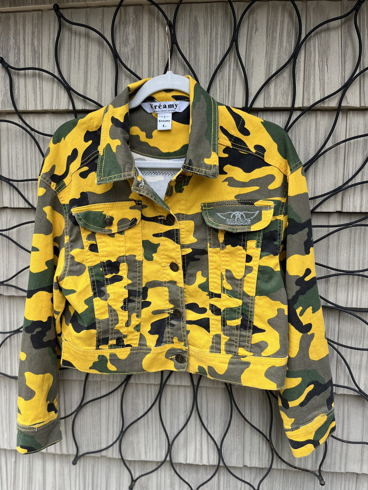 a yellow camouflage jacket hanging on a wall.