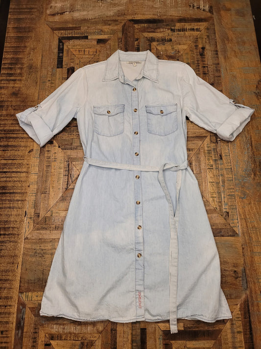 a white shirt dress sitting on top of a wooden floor.