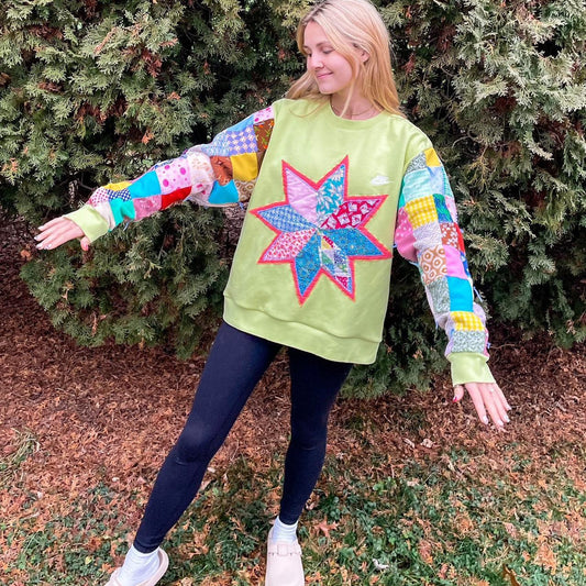 a woman wearing a green star patchwork sweatshirt.