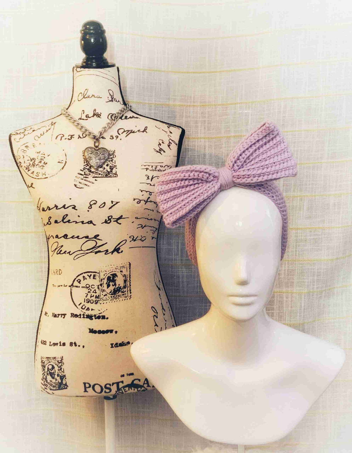 a white mannequin with a pink bow next to a white mannequin.