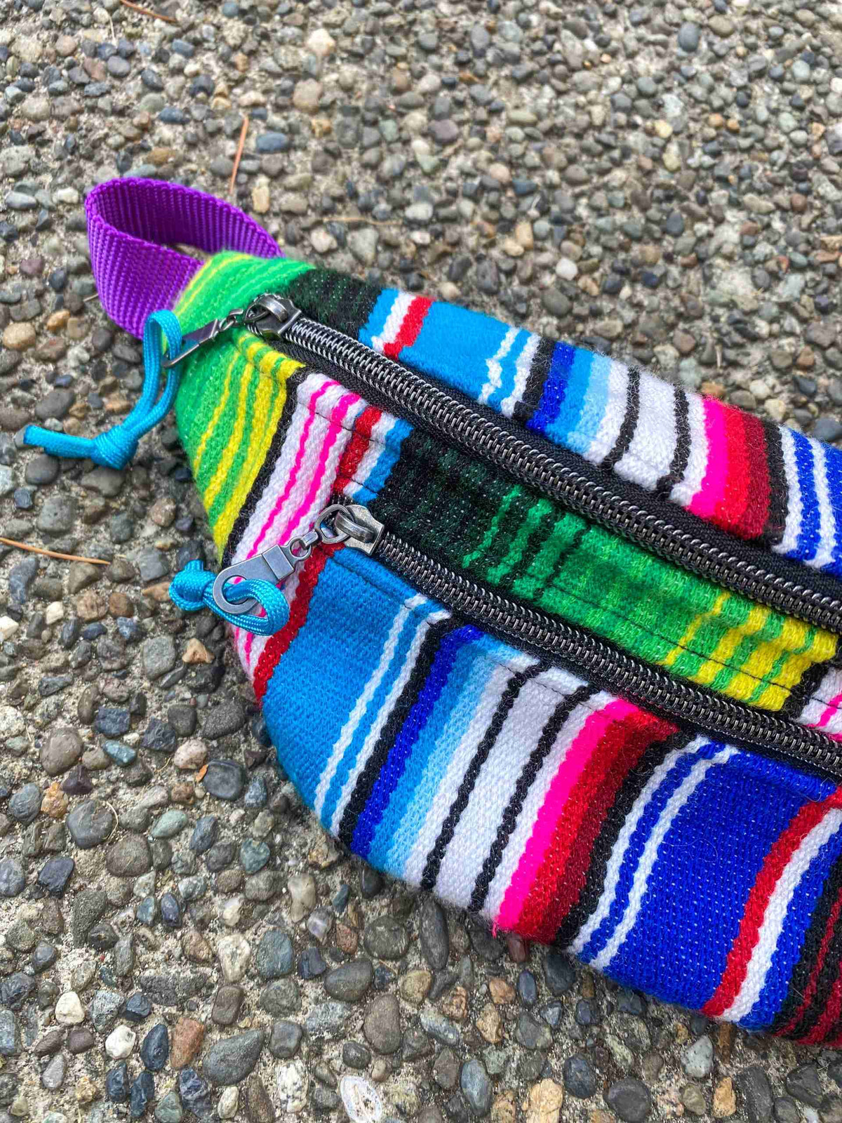 a multicolored striped purse laying on the ground.