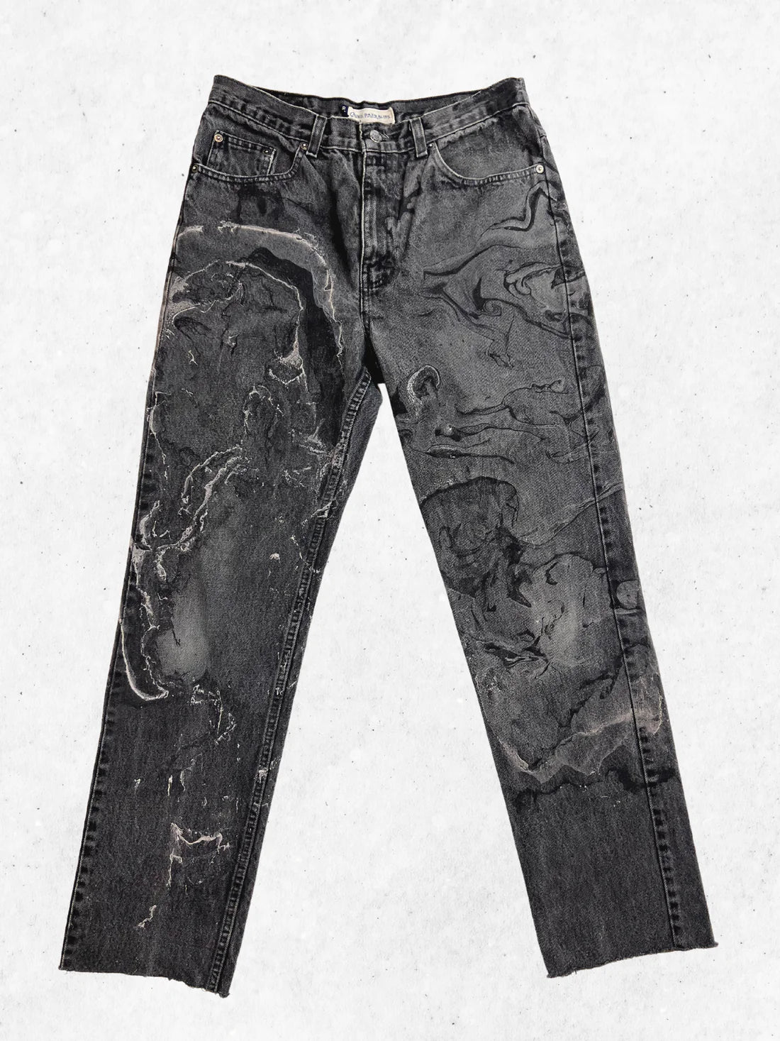A pair of black jeans with black paint on them.