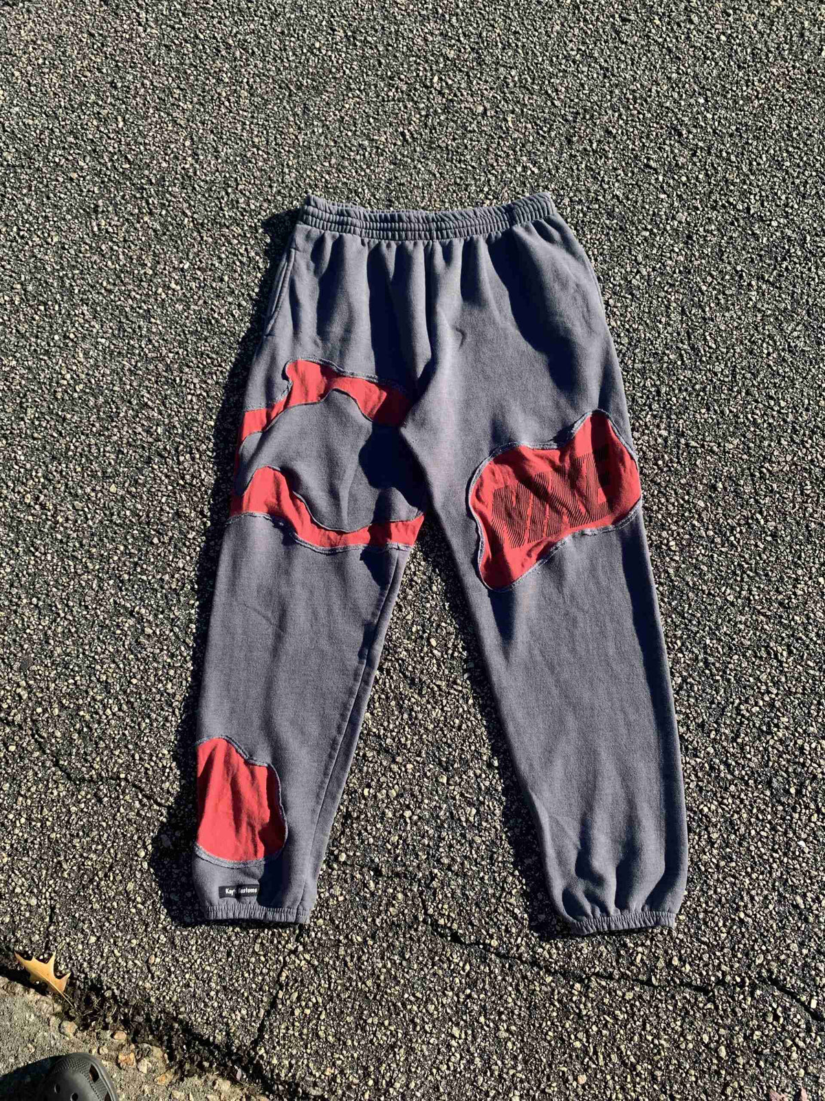 a pair of gray and red pants laying on the ground.