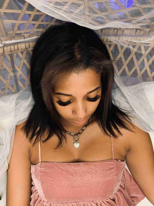 a woman in a pink dress laying on a bed.