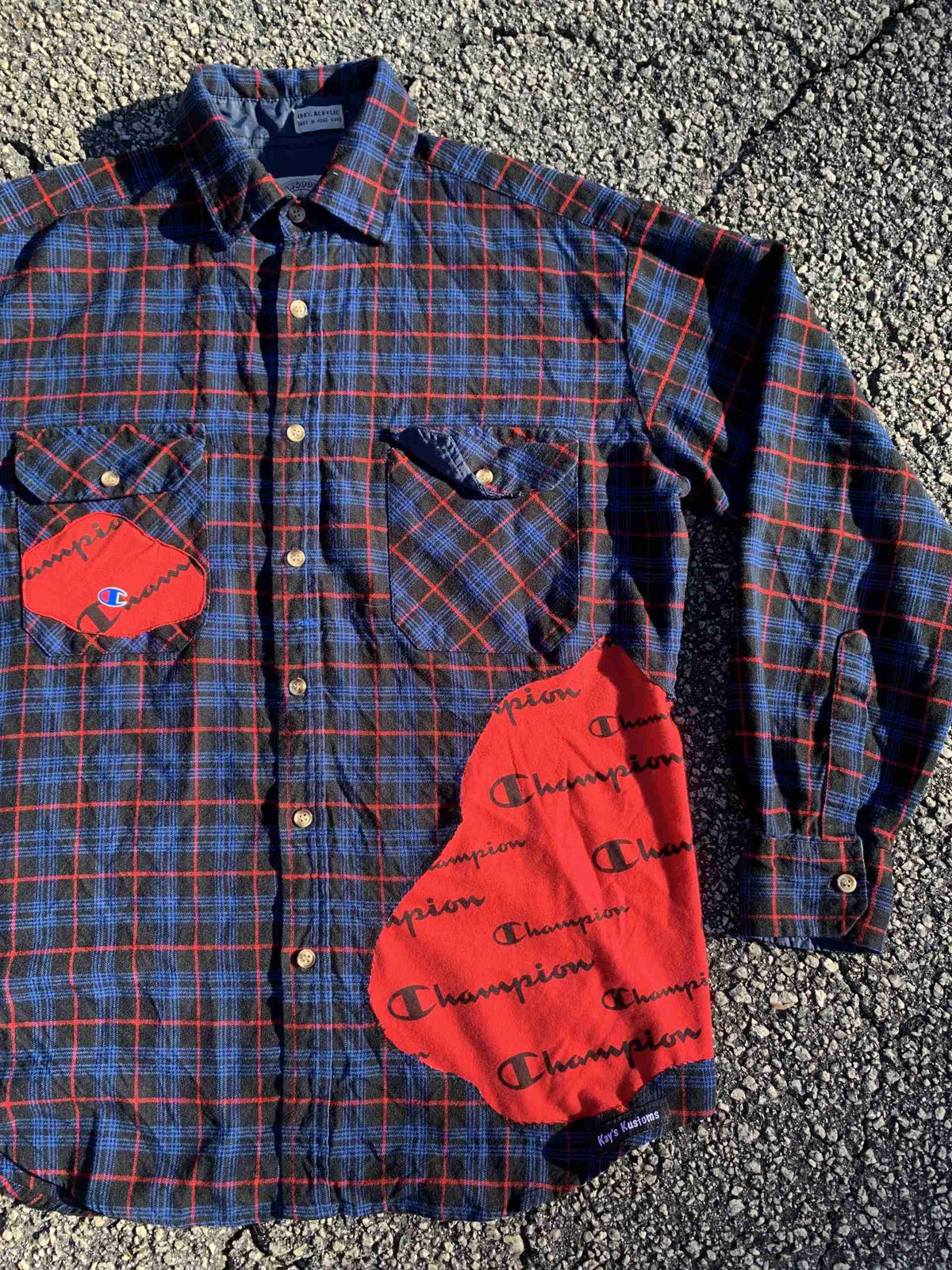 a blue and red plaid shirt with patches on it.