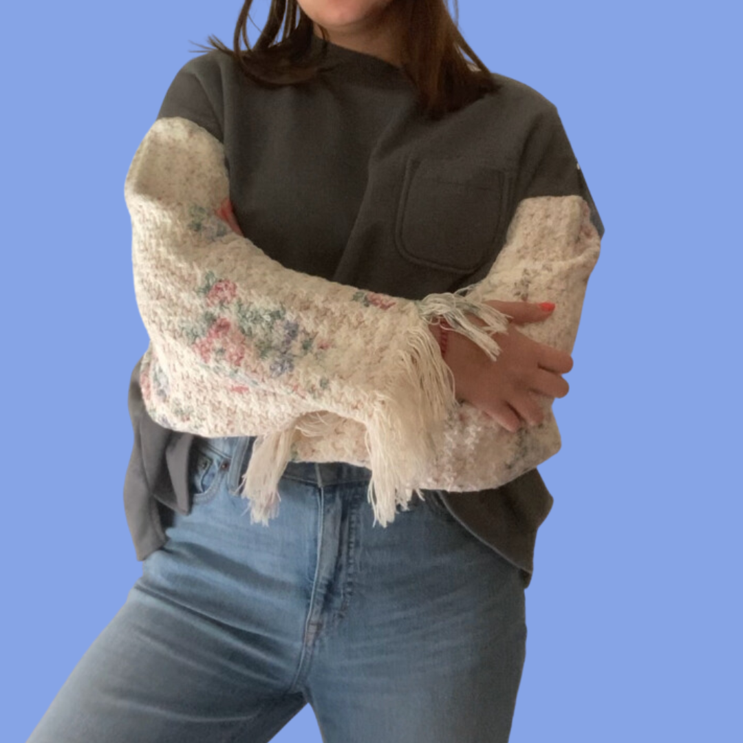 A woman wearing jeans and a sweater.