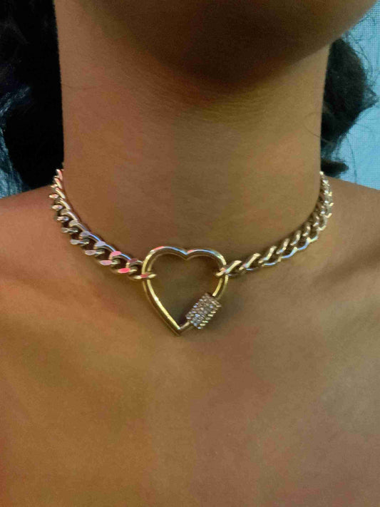 a woman wearing a necklace with a heart shaped lock.