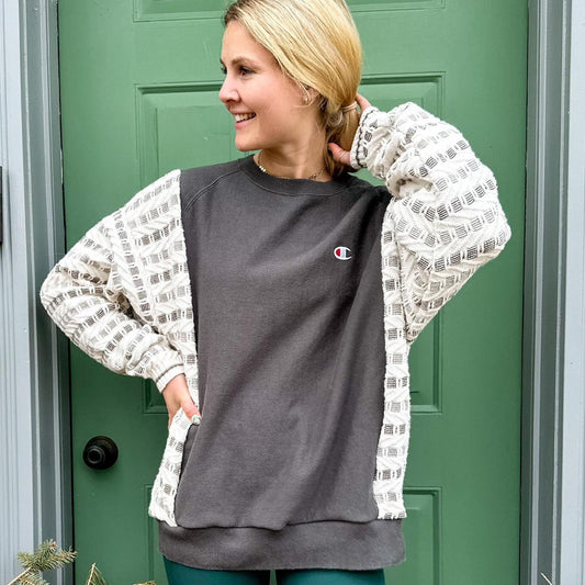 a woman standing in front of a green door wearing a Reworked Vintage Champion Neutral Crewneck.