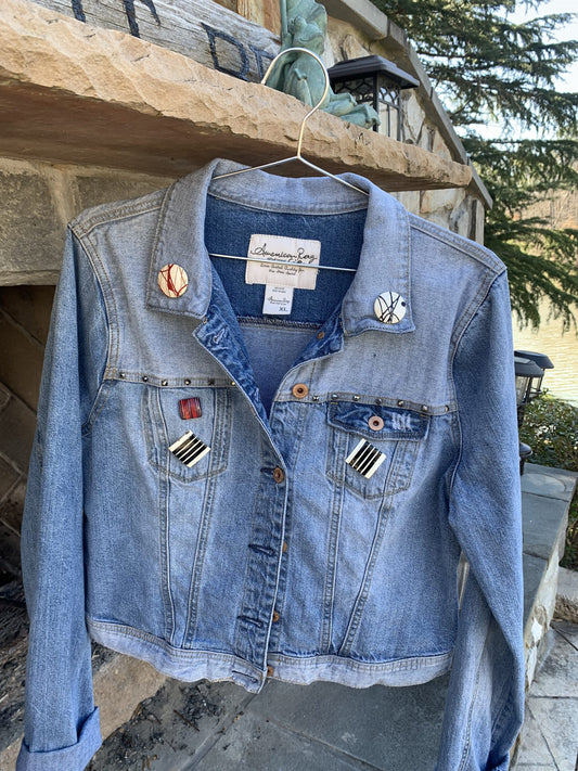 A Rolling Stones Denim Jacket hanging on a clothes rack.