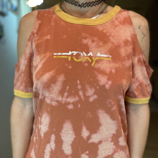 A woman wearing a Roxy tie dye cut-out tee and a choker.