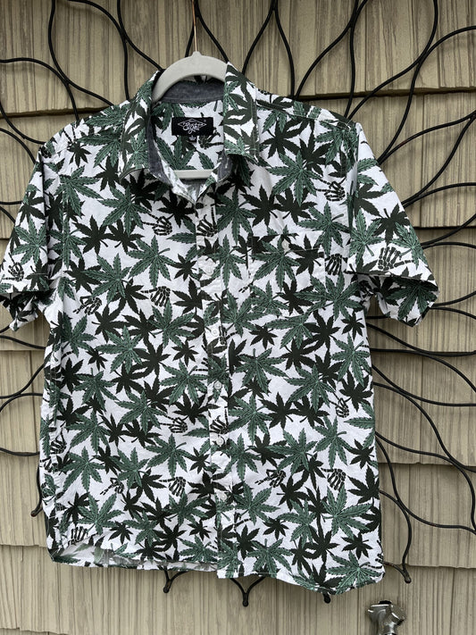 a shirt with green and black leaves hanging on a wall.