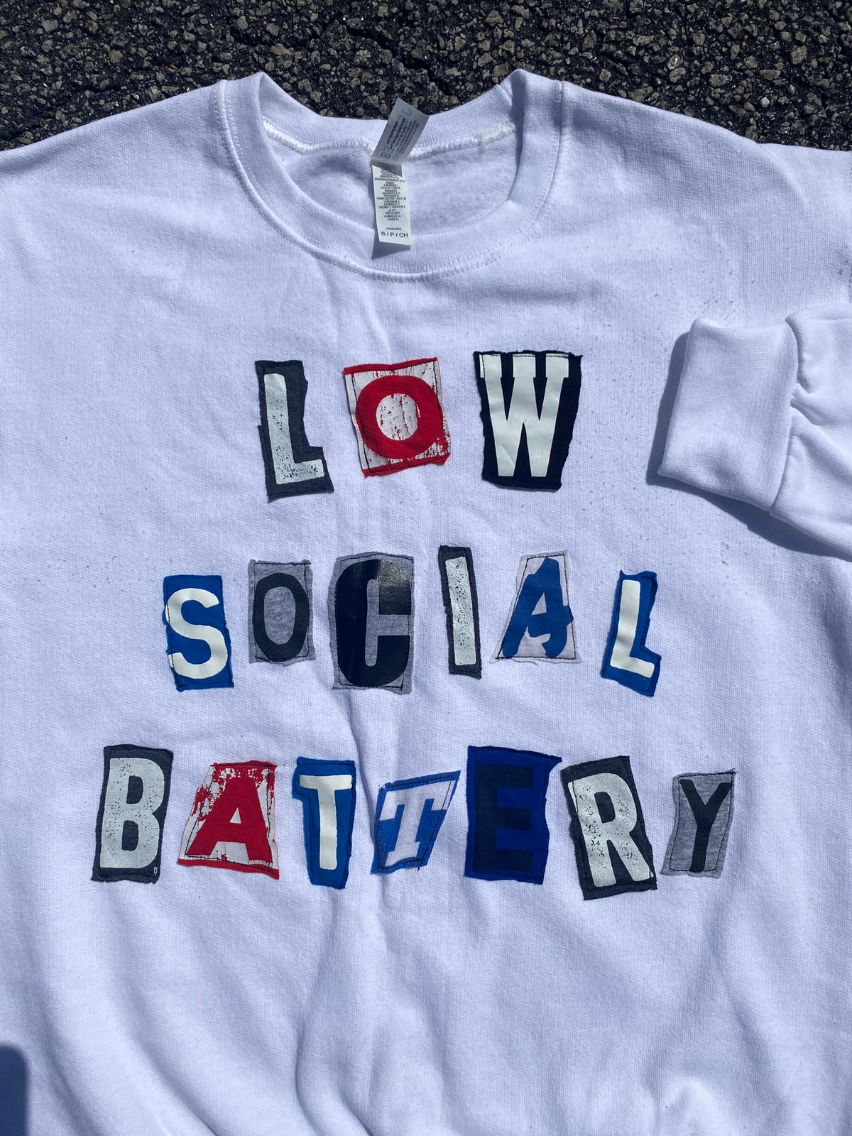 a white t - shirt that says low social battery.