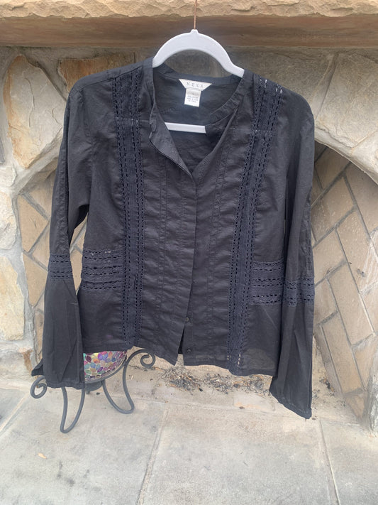 a black jacket hanging on a stone wall.