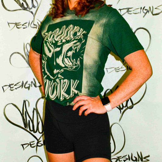 a woman wearing a green shirt and black shorts.