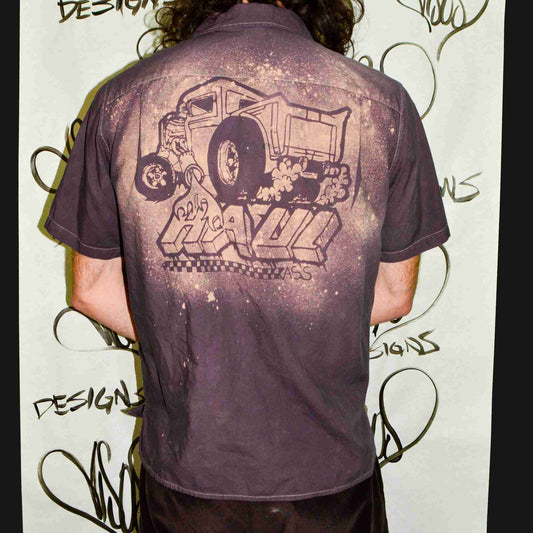 a man with long hair wearing a purple shirt.