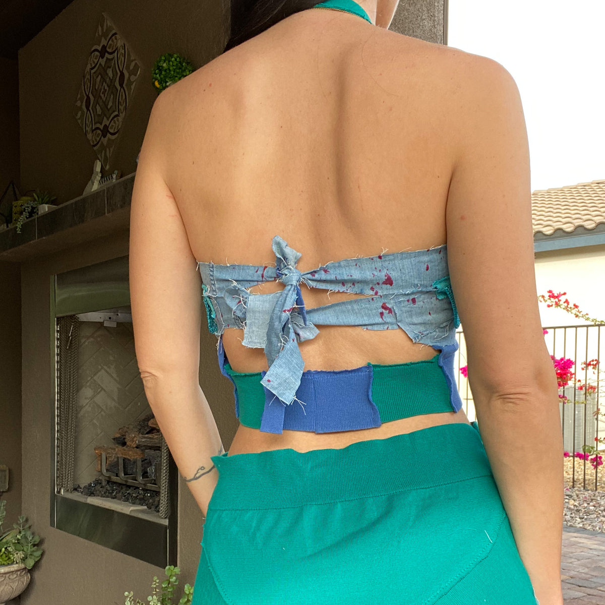 A woman wearing a 1of1 patchwork green and blue halter top & skirt set.