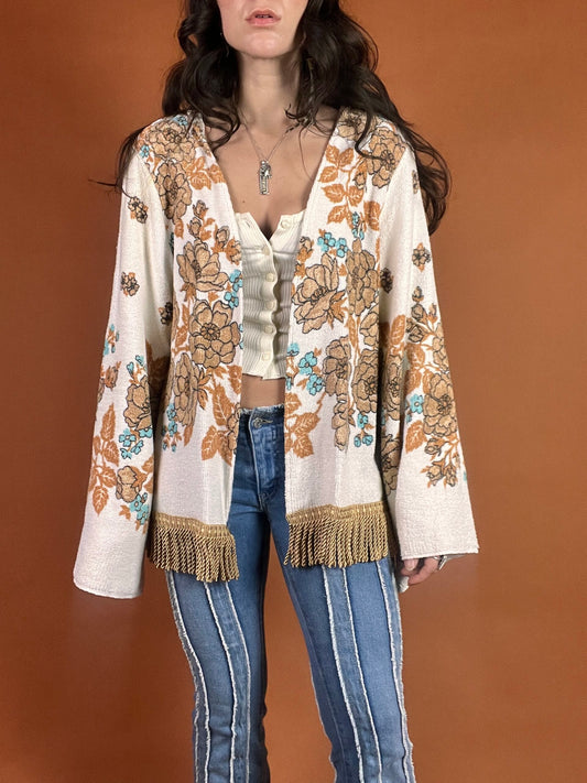 A woman wearing a fringed jacket and jeans.