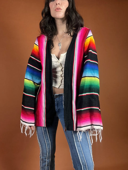 A woman wearing a colorful mexican cardigan.
