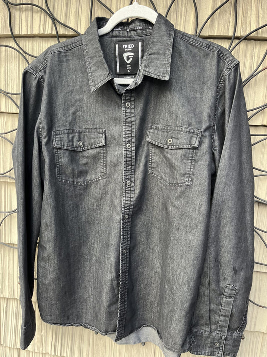 A grey button down shirt hanging on a wall.