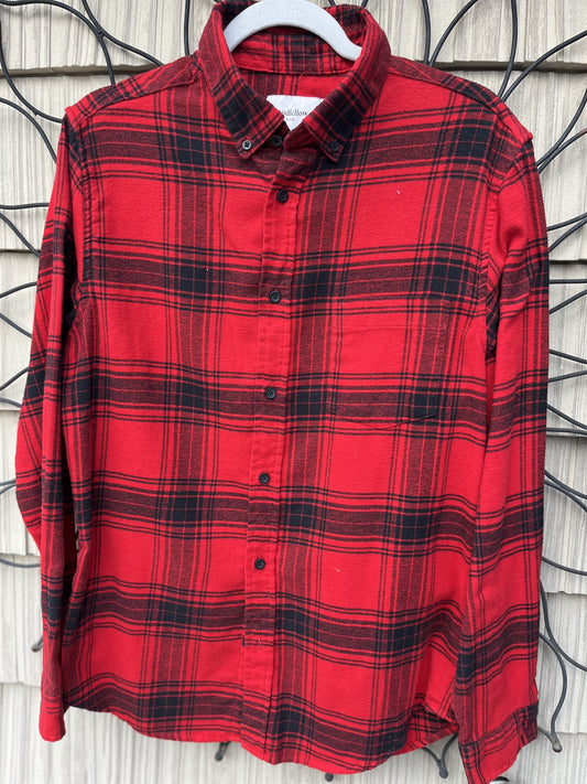 A red and black plaid shirt hanging on a wall.