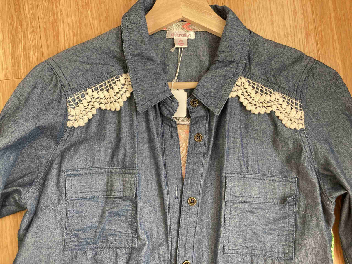 a denim shirt with white lace on the sleeves.