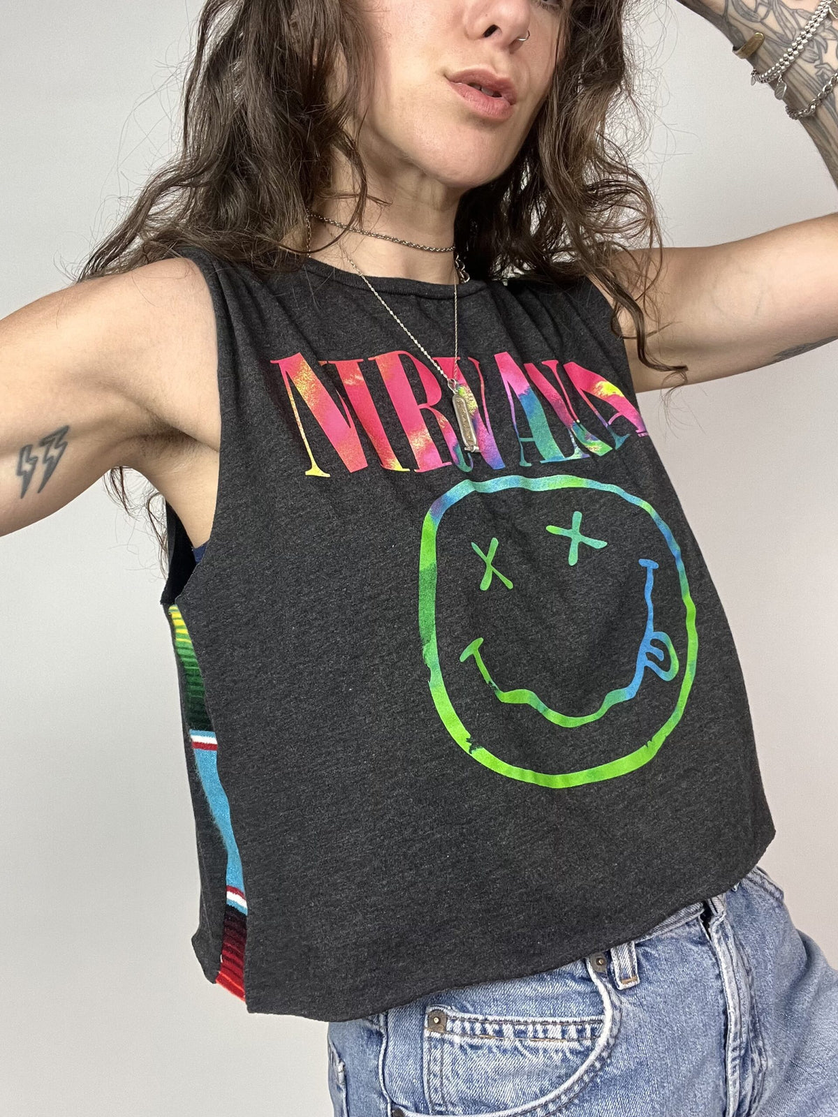 a woman wearing a black tank top with a smiley face on it.