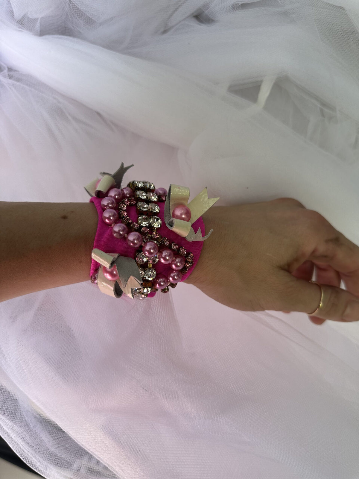 A woman wearing a pink bracelet on her wrist.