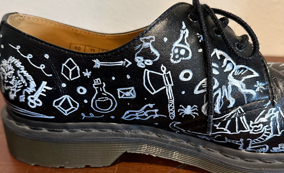 A black shoe with white drawings on it.