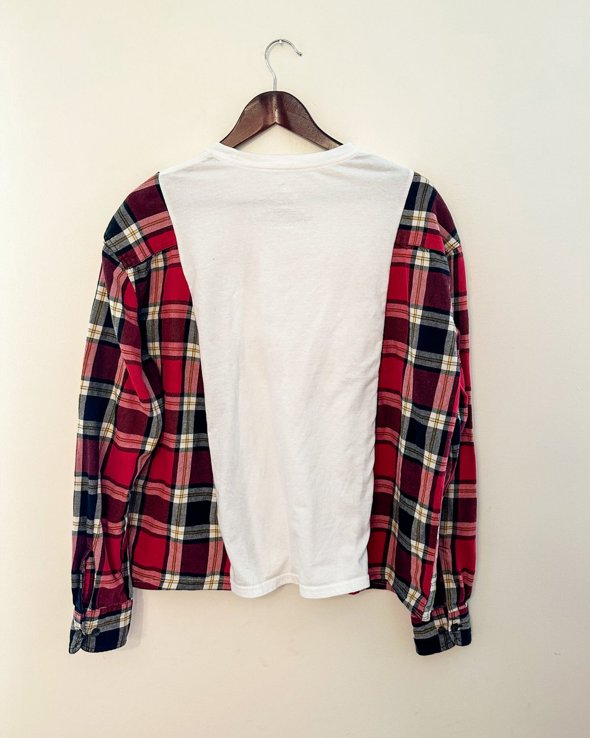 A red and white plaid shirt hanging on a wall.