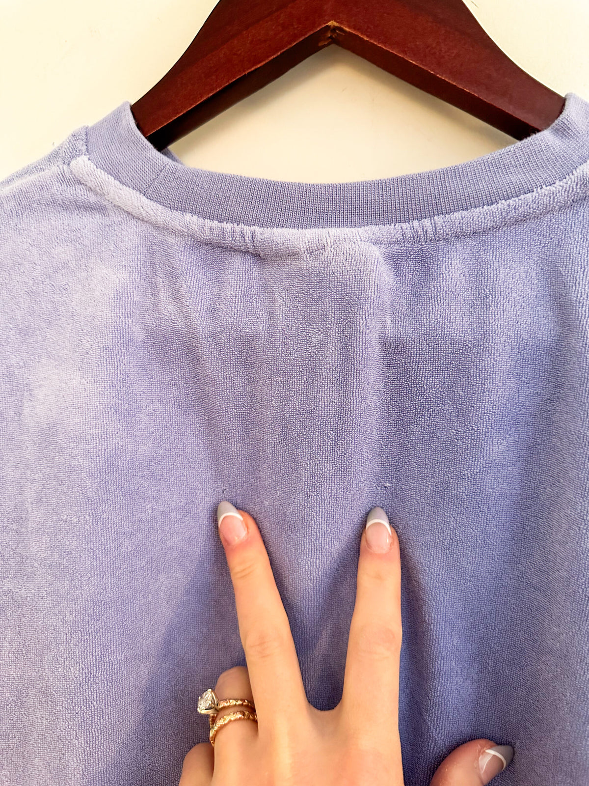 The back of a person's shirt with a finger on it.