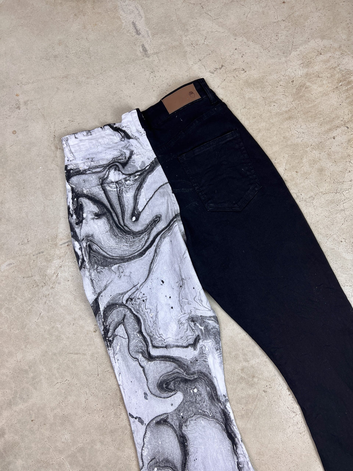 A pair of black and white marbled jeans.