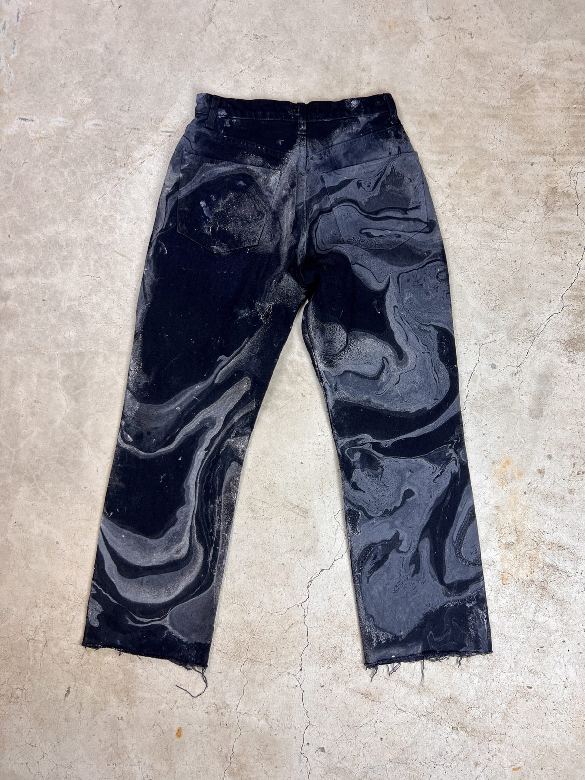 A pair of black pants with a marbled pattern.