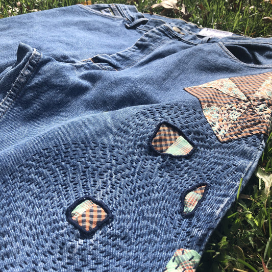 A pair of denim jeans with patches on them.