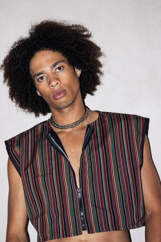 A young man in an Upcycled Sleeveless Cropped Jacket, One Size Fits Most, 1 of 1, posing for a photo.