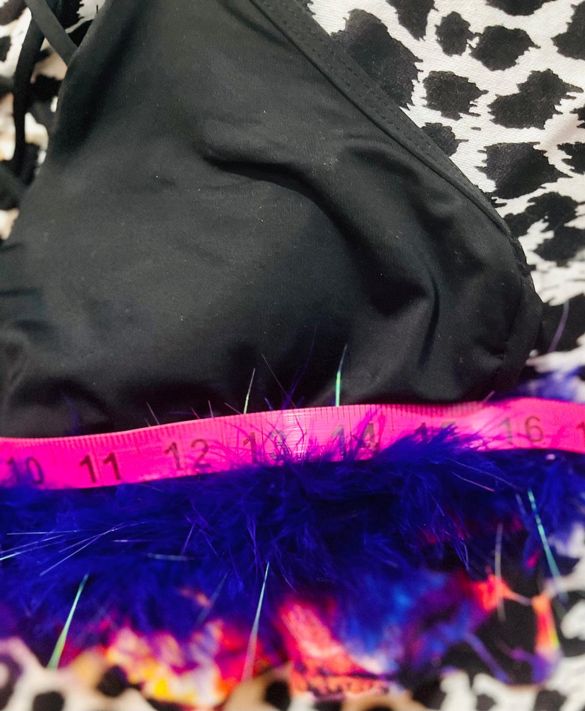 A black bikini with purple feathers and a measuring tape.