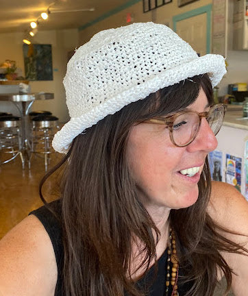 A woman wearing a white crocheted hat.