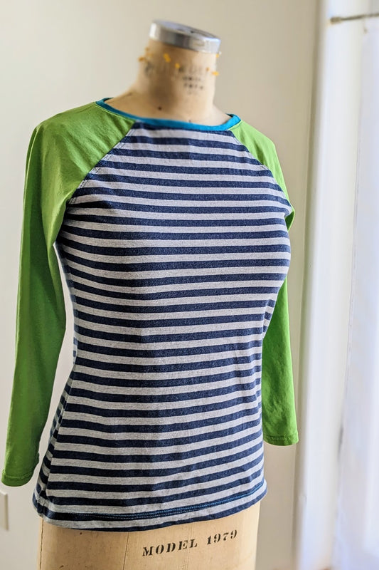 A blue and green striped t - shirt on a mannequin.