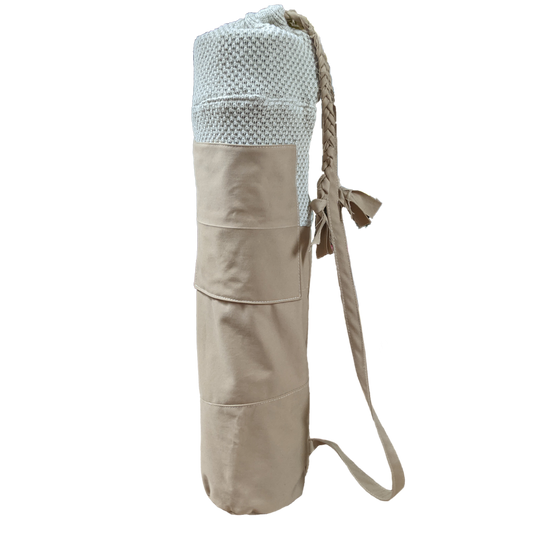 A beige yoga mat with a strap on it.