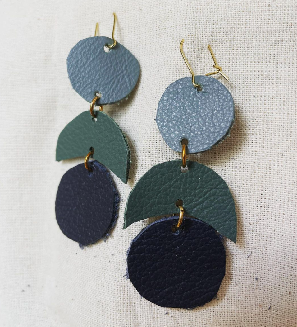 a pair of blue and green leather earrings.