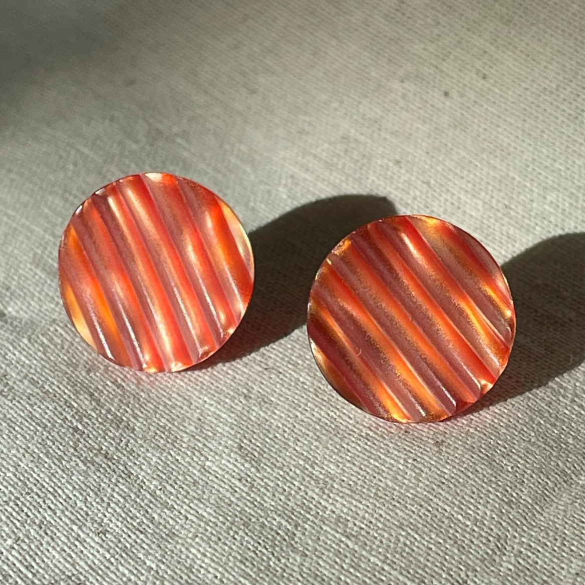 a pair of earrings sitting on top of a table.