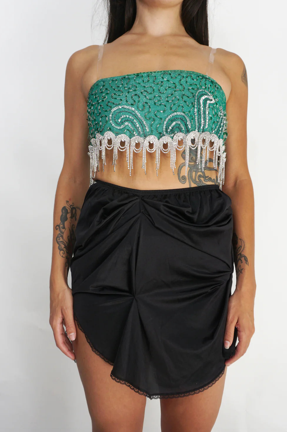A woman wearing a LACE ICING Black Mini Skirt and a green top.