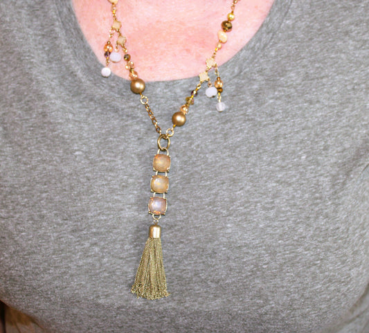 A woman wearing a necklace with a tassel.