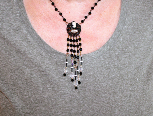 A woman wearing a necklace with a beaded tassel.