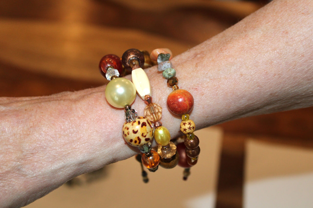 A woman wearing a bracelet with a lot of beads on it.