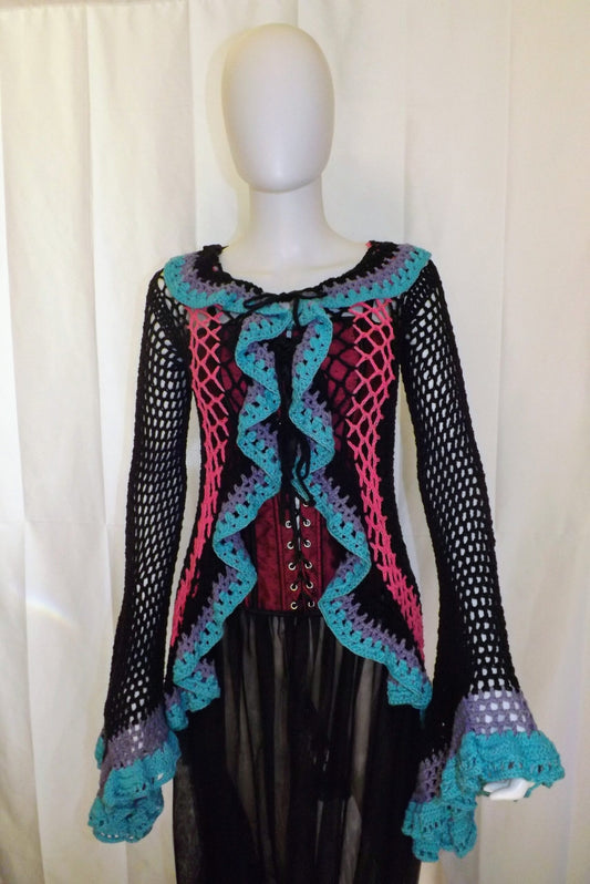 Crochet duster coat in blue, pink, purple and black has bell sleeves and a ruffled front.