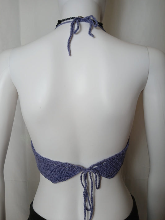 The back of a mannequin wearing a crochet top.